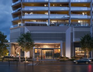 Entrée d'immeuble résidentiel moderne avec façade illuminée au crépuscule