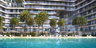Immeuble résidentiel avec piscine, chaises longues et palmiers