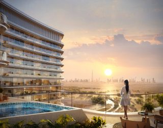 Femme sur un balcon avec la silhouette de Dubaï au coucher du soleil